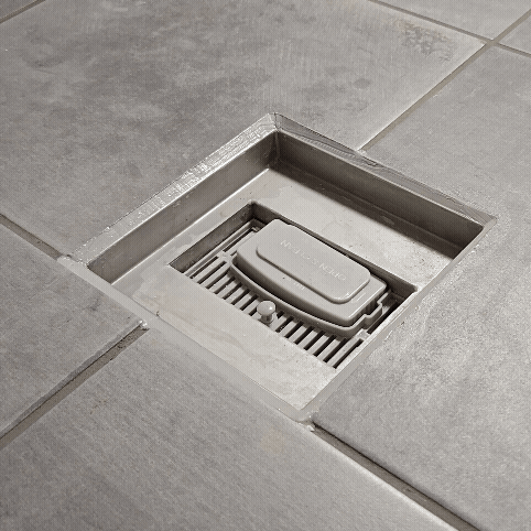 Eindresultaat sanitaire kitvoegen drain en vloer/wand